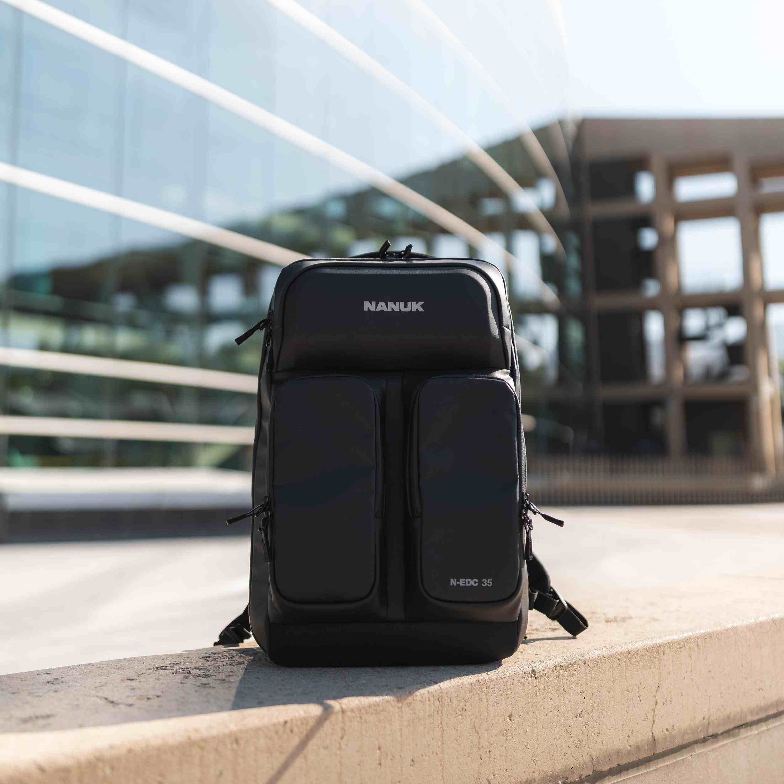 Schwarzer Rucksack mit „NANUK“-Logo auf einem Betonvorsprung vor einem modernen Gebäude im Hintergrund. Schwarzer Rucksack mit „NANUK“-Logo auf einem Betonvorsprung vor einem modernen Gebäude im Hintergrund.