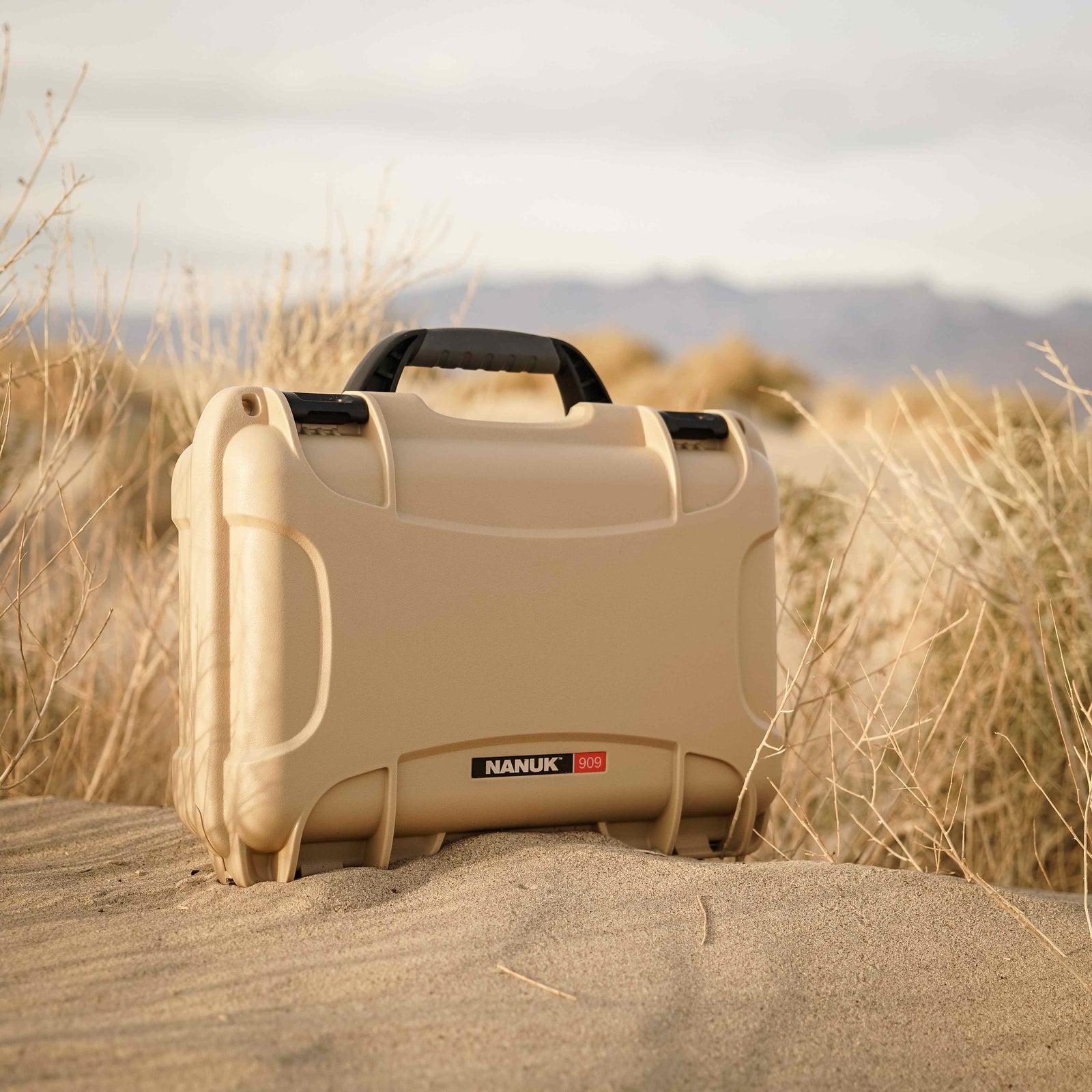 Kompakte und robuste NANUK 909 valise in hellbraun, perfekt geeignet für raue Wüstenbedingungen.