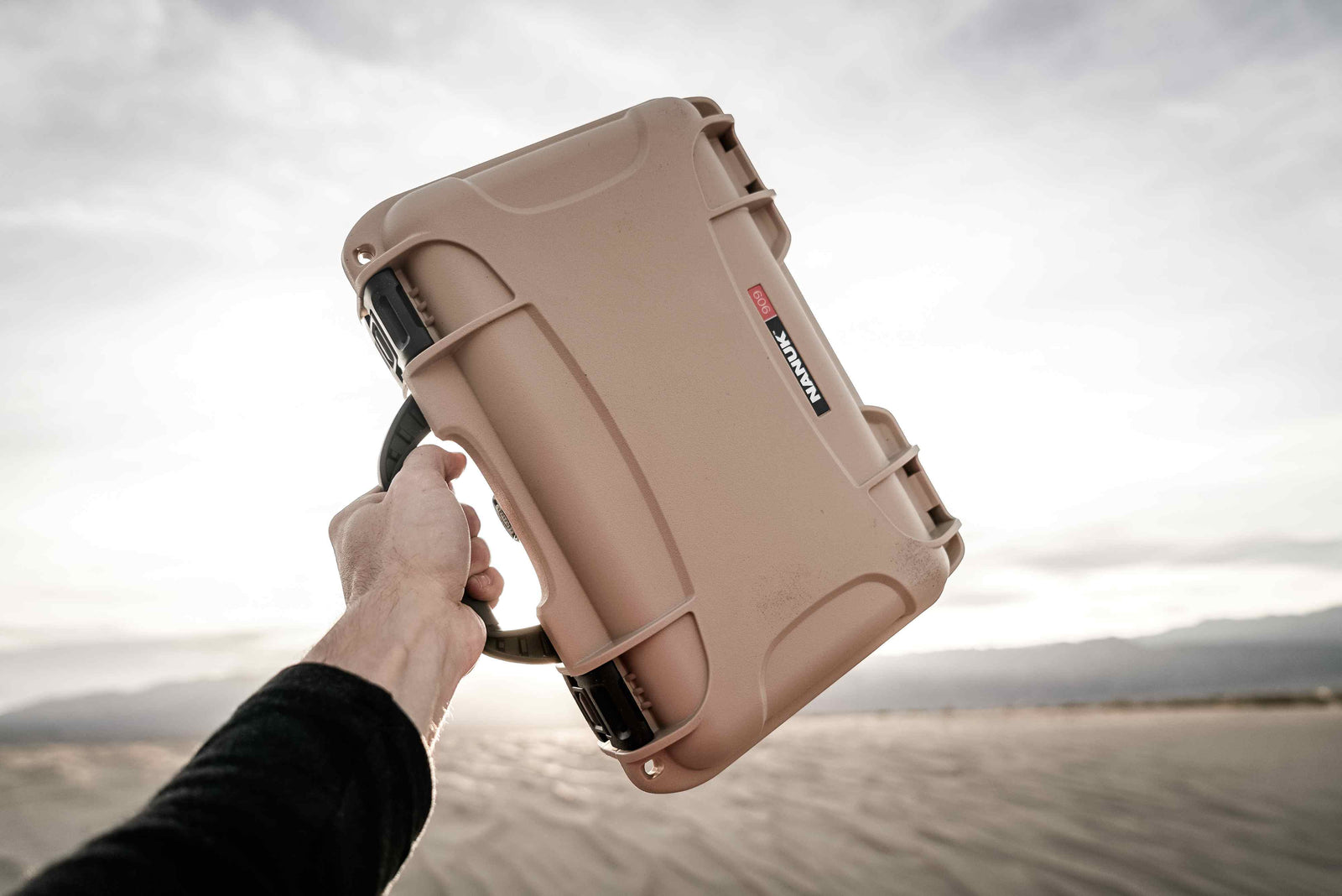 Nahaufnahme einer gebräunten NANUK 909 valise, die ihre Widerstandsfähigkeit in einer rauen Wüstenumgebung unter Beweis stellt.