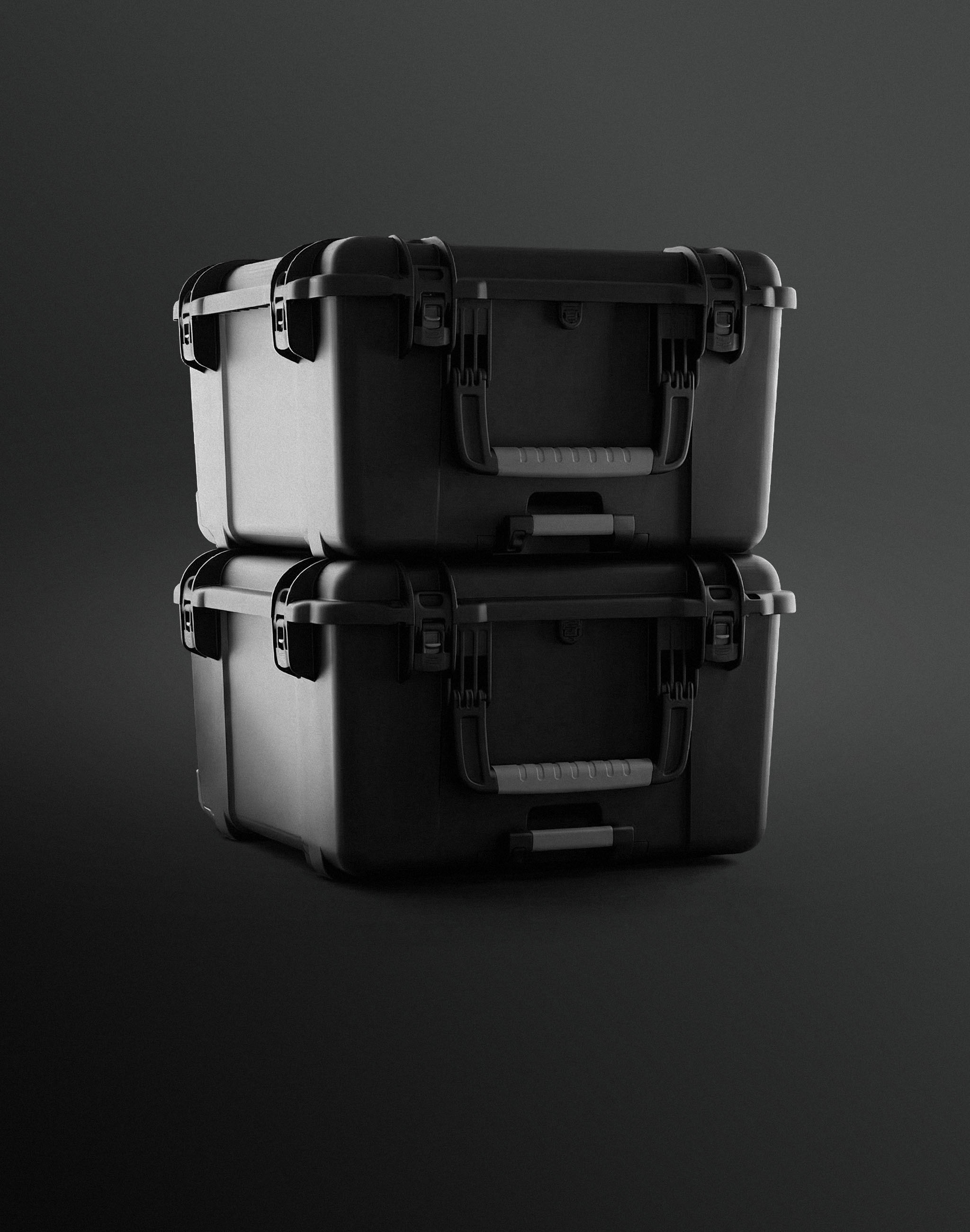 Two black, rugged Nanuk cases are stacked on a dark, minimalist background, highlighting their protective design, handles, and latches.