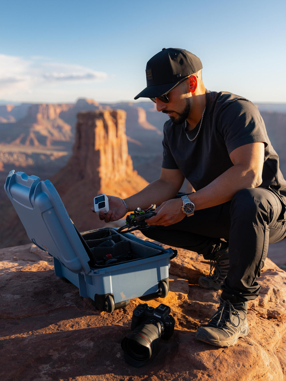 Man in a desert landscape with a blue case and equipment