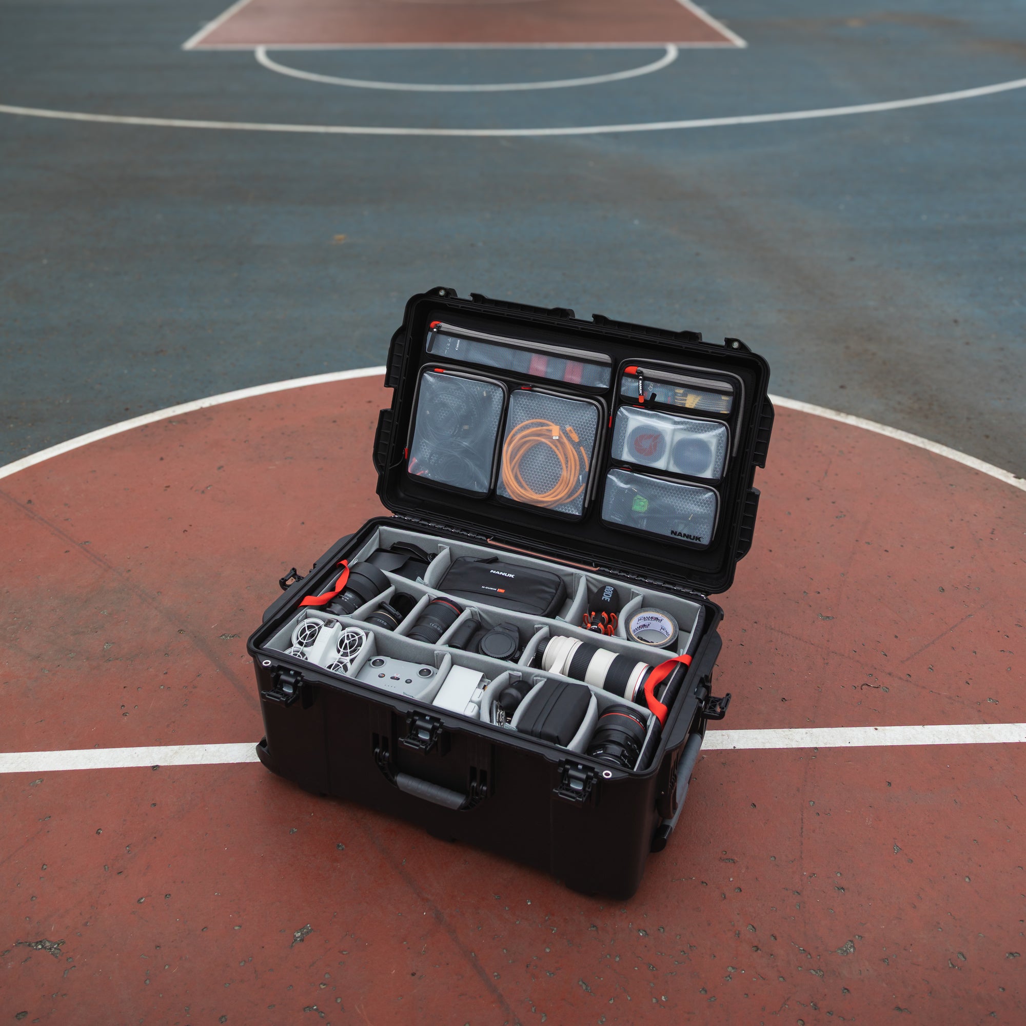NANUK 965 Camera Valise - Pro Photo Kit sur un terrain de basket à l'extérieur.
