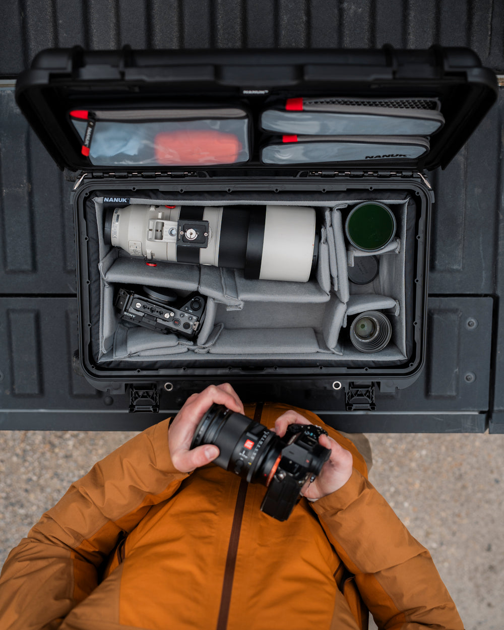 Camera equipment in a black carrying case with a person holding a camera.