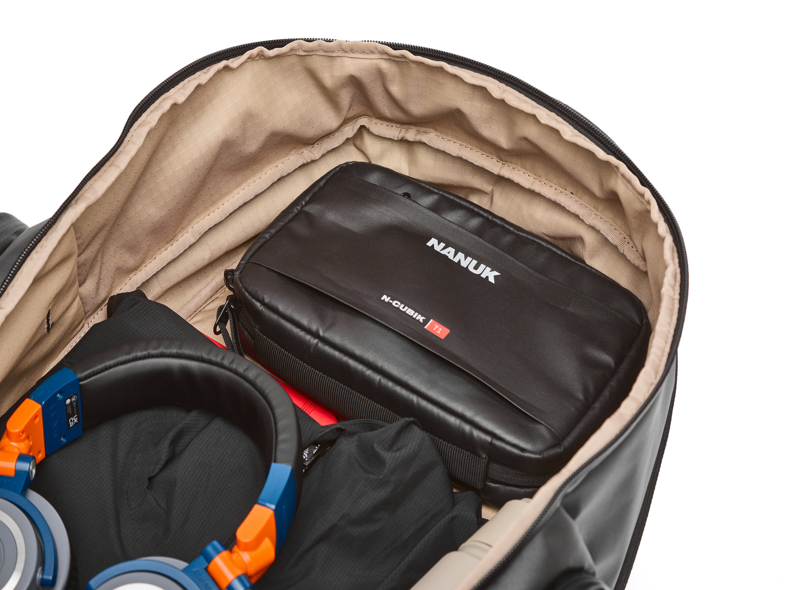 Nanuk-Tragetasche in einer größeren Tasche, Kopfhörer sichtbar