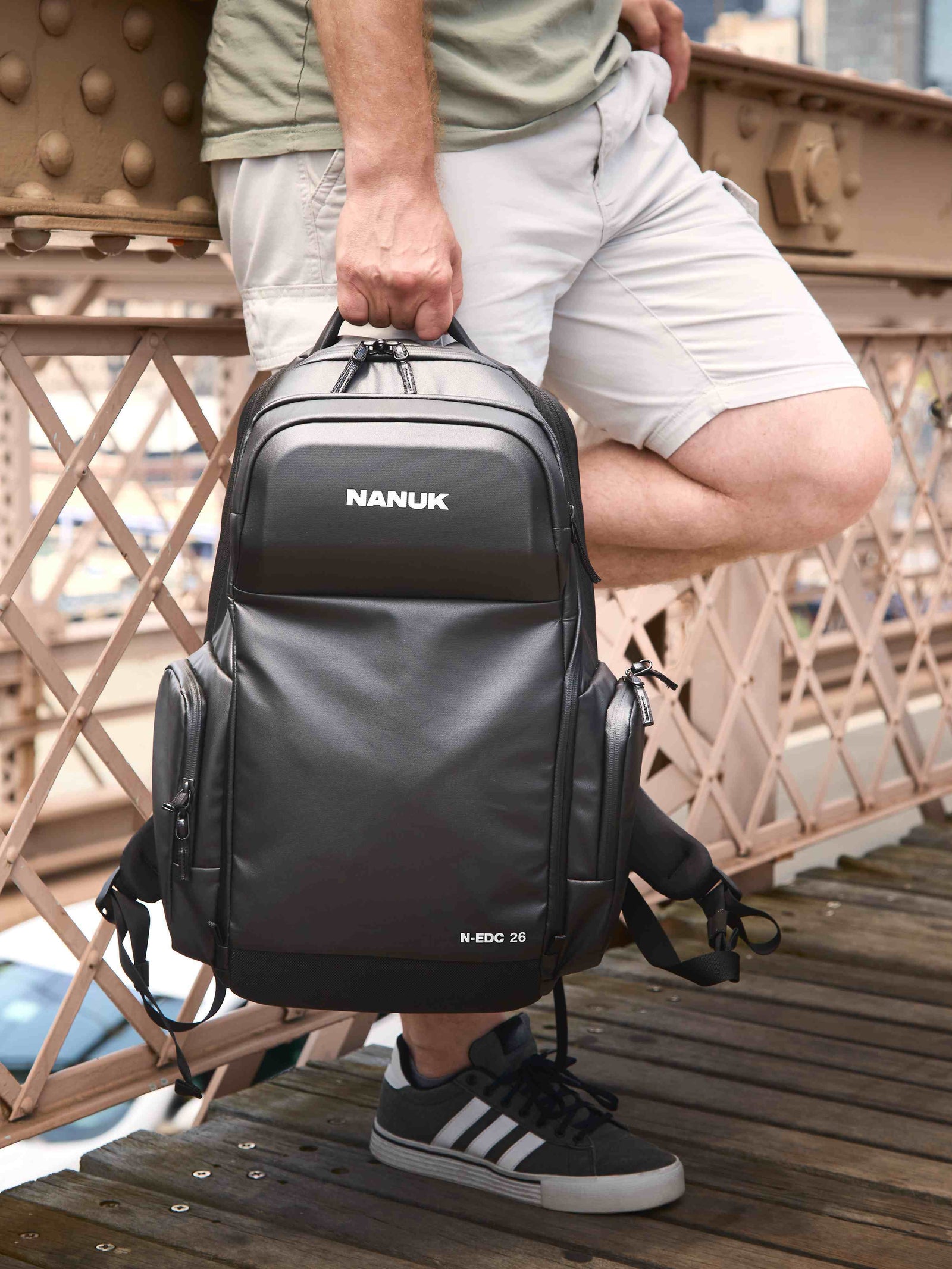 Person mit einem NANUK-Rucksack auf einer Brücke
