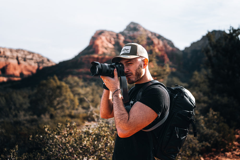 Man with camera and backpack in a mountainous landscape