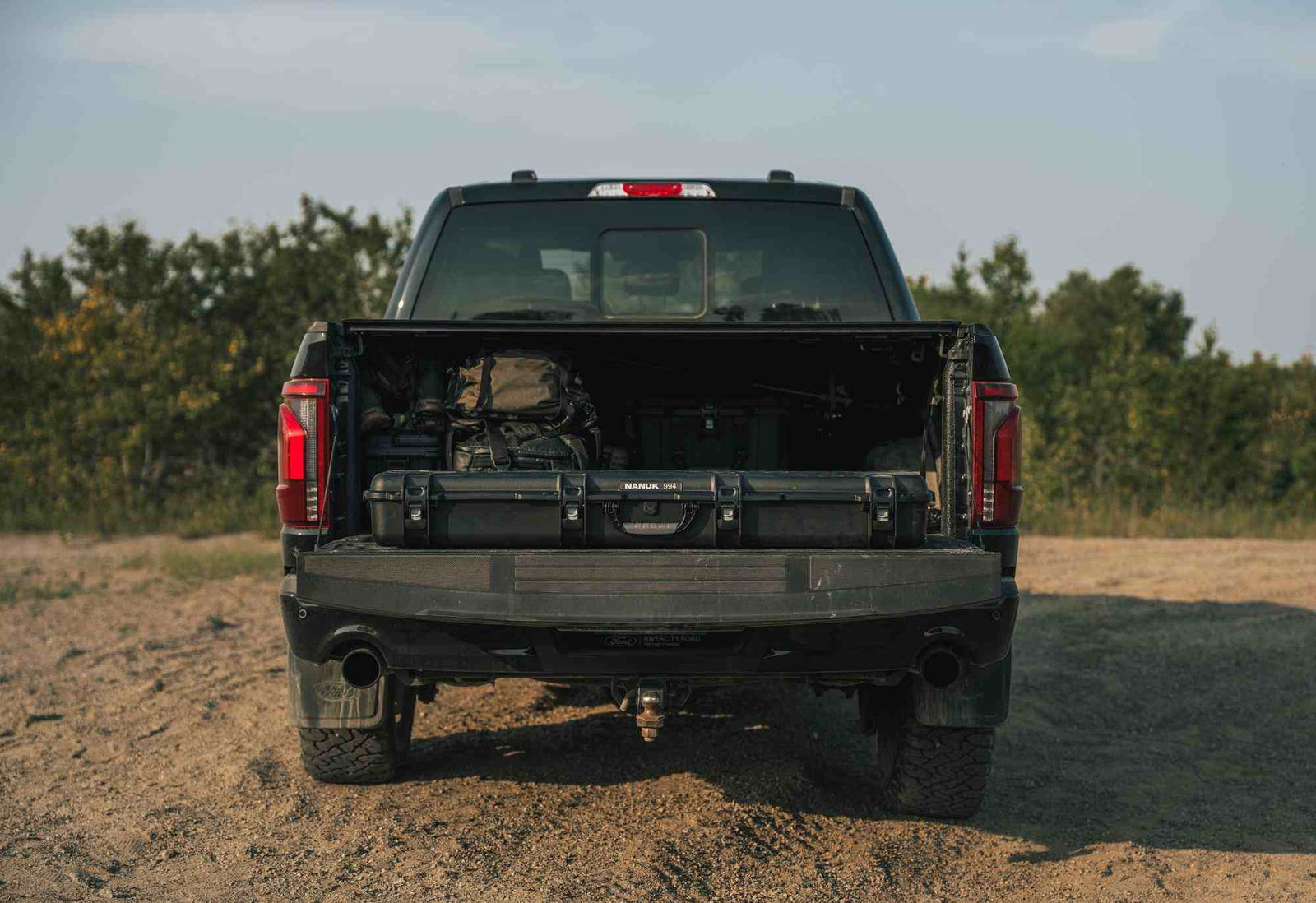 Schwarzer Pick-up mit offener Ladefläche auf einem Feld