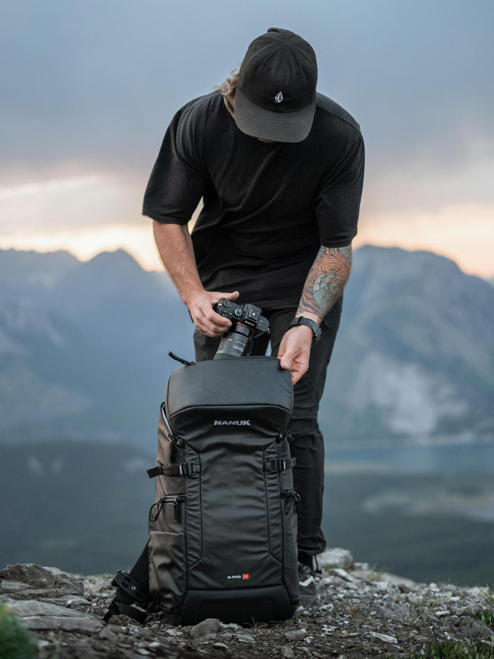 Person with a backpack on a mountain top with a scenic background