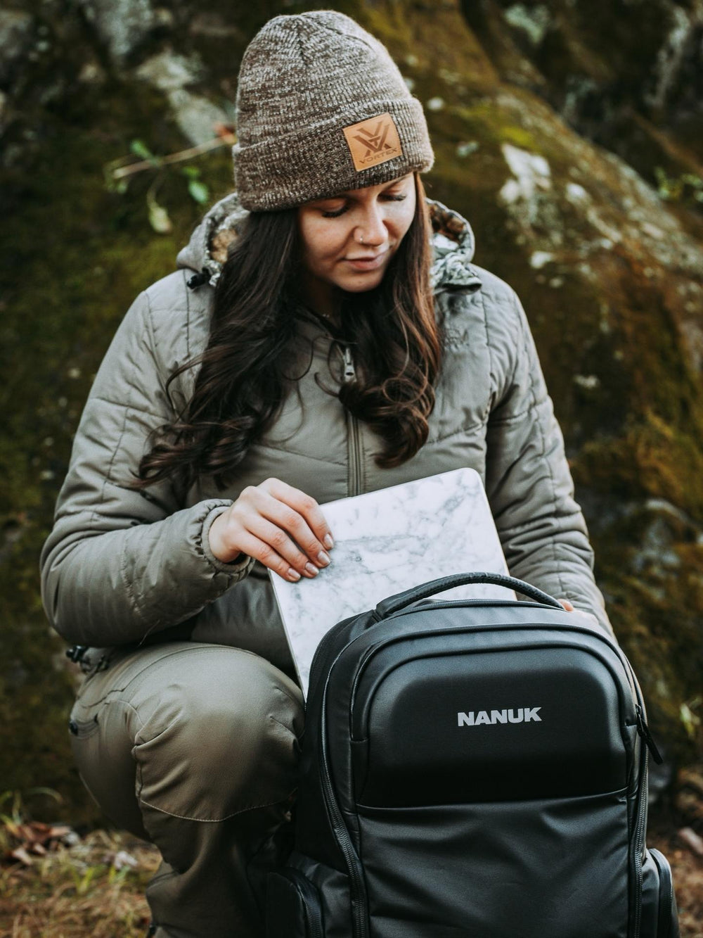 Person in outdoor setting with a map and Nanuk backpack