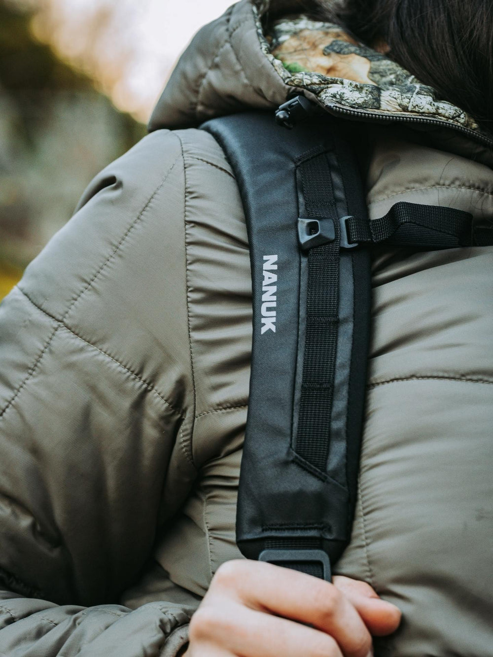 Person wearing a backpack with a visible Nanuk brand logo.