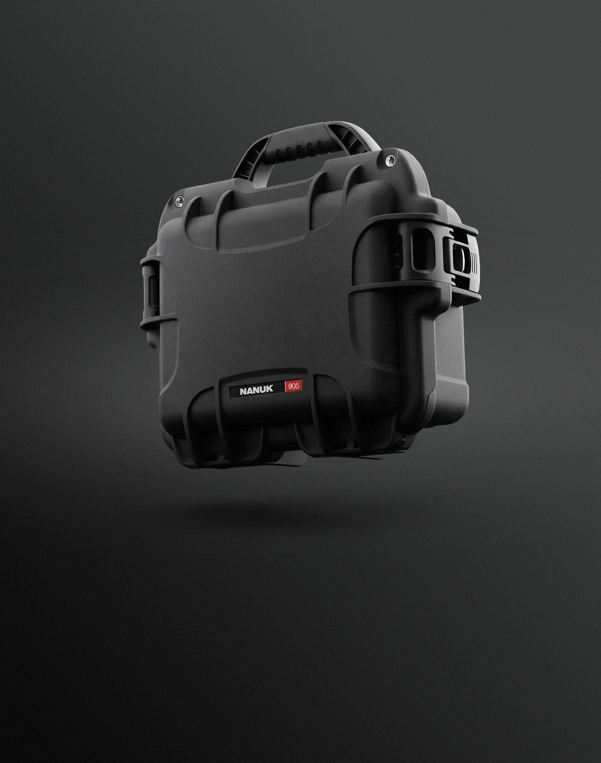 Black Nanuk 905 protective hard case, a type of nanuk case, floats angled against a dark grey background.